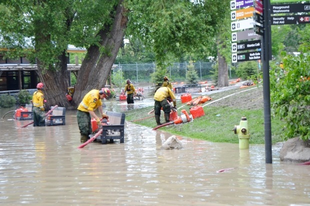 Emergency responders in personal protective equipment deploying pumps in urban floodwater